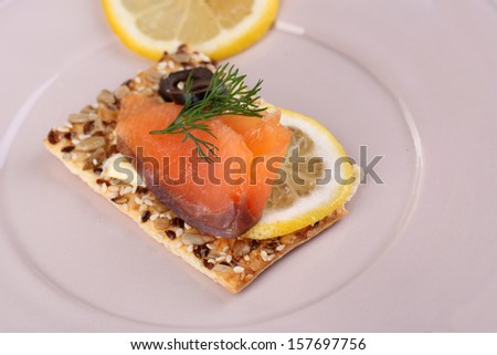 Salmon sandwich on plate  on wooden table close-up