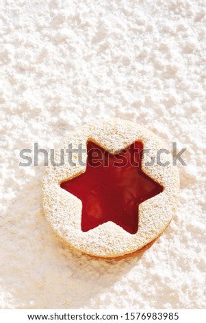 Short pastry jam biscuit, on icing sugar