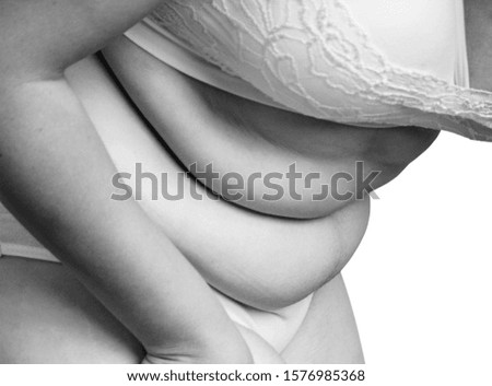 Fat and flabby female belly with abdominal folds. Isolated on white.