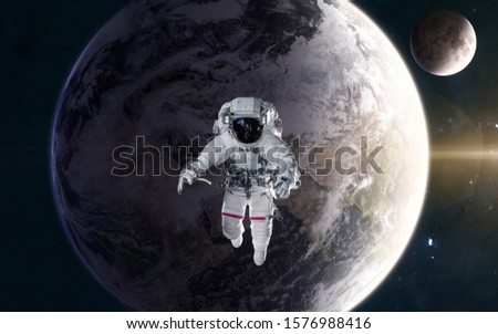 Astronaut in outer space in orbit of the planet Earth in warm light of Sun. Moon. Solar system. Science fiction. Elements of this image furnished by NASA