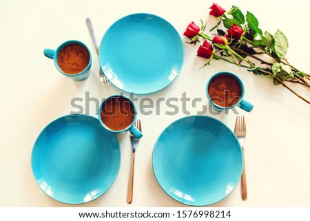 Valentines day table setting with plate, fork and red roses, top view. Holidays breakfast and romantic. Beautiful roses for wife, girlfriend at table. Morning mood with flowers
