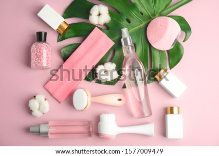 Flat lay composition with face cleansing brushes on violet background. Cosmetic tools