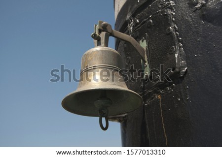 the old ship's bell on the background of blue sky