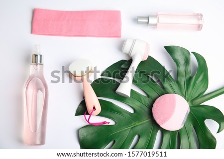 Composition with face cleansing brushes on white background, top view. Cosmetics tools