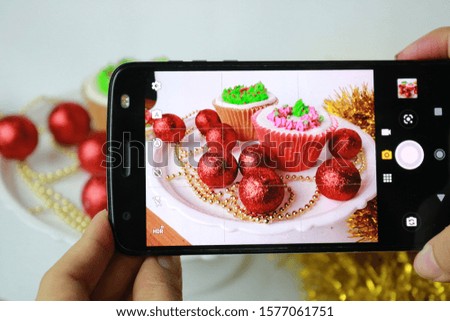 
taking picture of christmas cupcake on cellphone