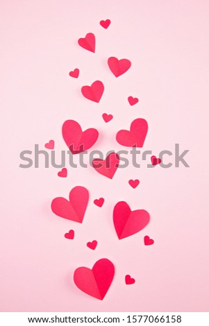 Paper hearts over the pink pastel background. Abstract background with paper cut shapes. Sainte Valentine, mother's day, birthday greeting cards, invitation, celebration concept
