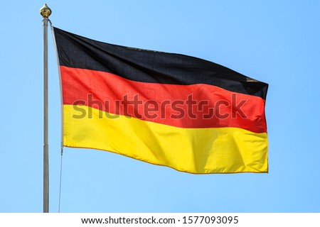 The national flags of Germany on the background of clear blue sky.