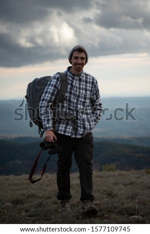 Photographer/filmmaker working in the mountains with a camera. 