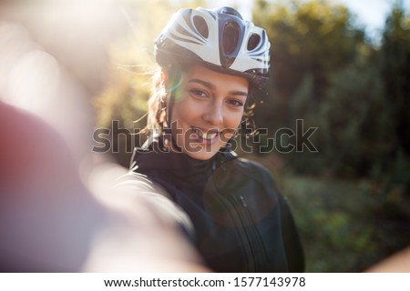 Happy active female cyclist make selfie