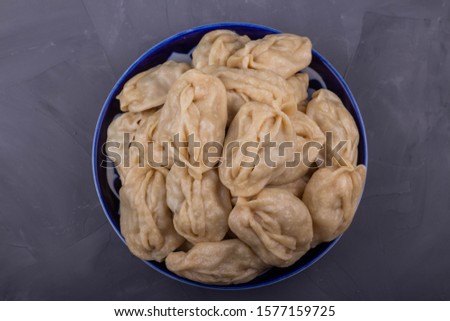Delicious mantas on a plate on gray background, Asian cuisine, traditional national dish.