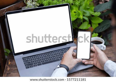mockup image blank screen computer,cell phone with white background for advertising text,hand man using laptop texting mobile contact business search information on desk in office.marketing and design