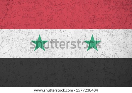 Syria flag depicted in bright paint colors on old relief plastering wall. Textured banner on rough background