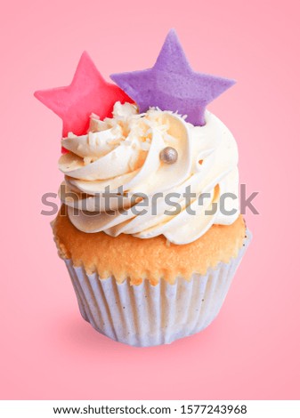 Cute little colourful pastel cup cake decorated with white chocolate star shape on light pink background for birthday party.