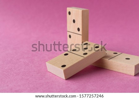 Playing dominoes on a purple background. Leisure games concept. Domino effect