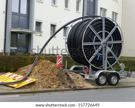Laying of fiber optic cable in Hanover, Germany. Glass fibers are employed as fiber optic cable for data transmission and for flexible transport of light. Royalty-Free Stock Photo #157726649