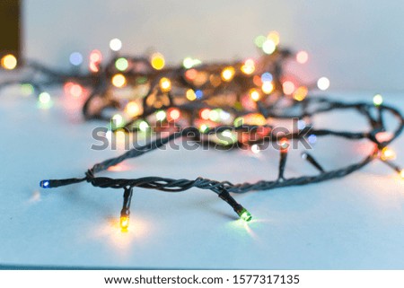 Christmas twisted garland lies on the table. Background for desktop, for social networks. Festive colored decorations for the new year.