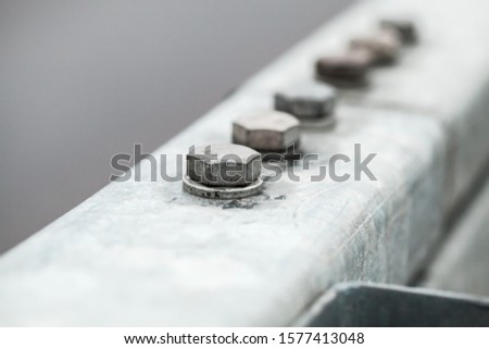 Abstract industrial background with gray bolts connection, close-up photo with selective soft focus
