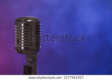 Retro microphone on dark color background with smoke