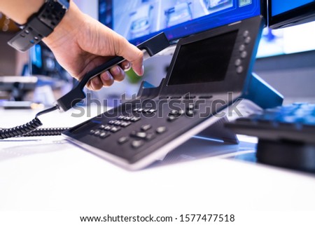 The hand is picking up the phone to notify the news in office. Royalty-Free Stock Photo #1577477518
