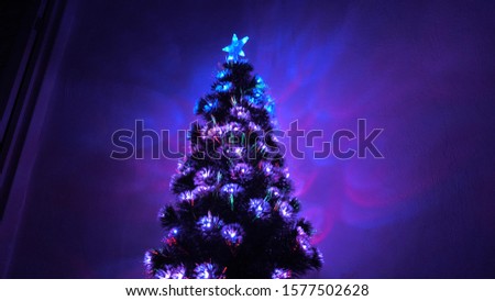 beautiful Christmas tree in room, decorated with luminous garland and a star. holiday for children and adults. New Year 2020 mood. Christmas tree, happy holidays. Christmas interior.