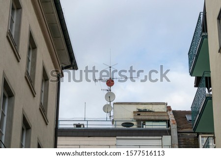 Parabolic mirror and TV antenna on a house roof