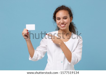 African american doctor woman isolated on blue background. Female doctor in white medical gown point finger on blank empty credit bank card. Healthcare personnel medicine concept. Mock up copy space