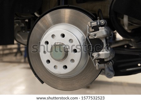 The brake mechanism of a modern car. Rear brake disc of a car with caliper, pads closeup. Technical photography.