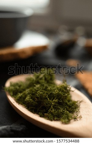 finely chopped dill on a wooden spoon closeup. selective focus