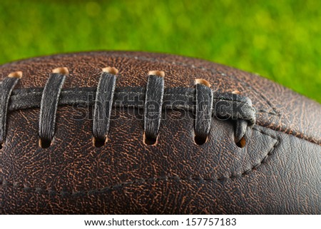 Leather Football in strict closeup with grass in the back