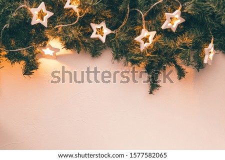 Christmas branches of spruce with burning garland on empty table