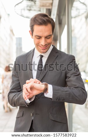 Businessman in suit looking to his wristwatch