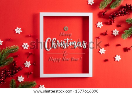 Christmas holidays composition Top view of white picture frame with Christmas tree decoration and red berries on green pastel background with copy space for text.