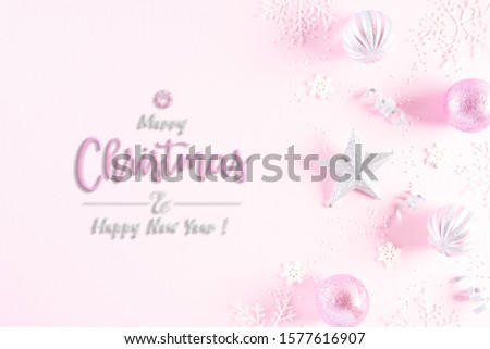Christmas background concept. Top view of Christmas ball with snowflakes on light pink pastel background.