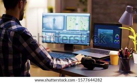 Movie maker editing a film using modern software for post production. Young videographer. Home office.