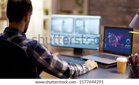 Content creator working on post production for a multimedia project in home office.