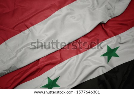 waving colorful flag of syria and national flag of indonesia. macro
