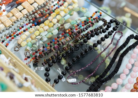 Colorful necklaces made from different precious stones for sale in jewelry store

