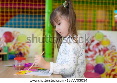 little girl draws in kindergarten