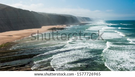 PORTUGAL, Praia do Magoito - Magoito Beach viewed from above. Magoito view with big vawes and misty, foggy air in September. Atlantic ocean coast at Portugal near Sintra and Lisbon.