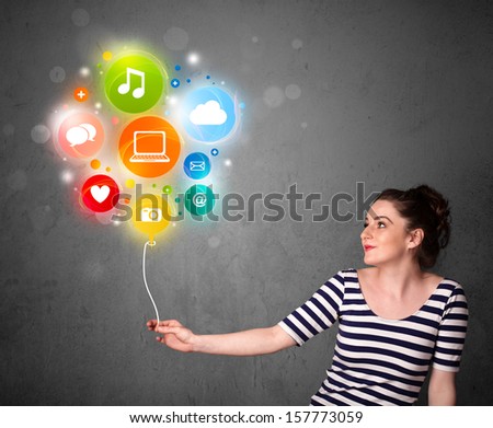 Pretty young woman holding colorful social media icons balloon