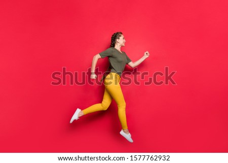 Full size profile photo of millennial lady jumping high sports competition marathon participant running speed wear casual yellow pants green t-shirt isolated red color background