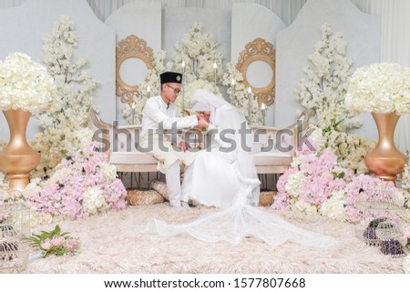 Indoor shooting for Malay wedding, the bride and groom wearing Malay traditional  cloth in solemnization of marriage ceremony . Happy & Family Concept