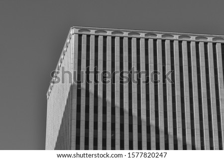 Black and White Building Panorama.  Sunlight and shadows on a high rise building with clear skies above.