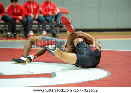 Boy High School wrestlers competing at a wrestling meet