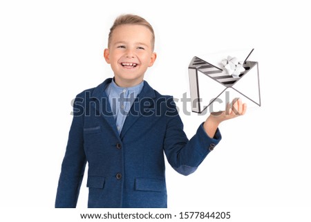 HAPPY LITTLE SMILING BOY LOOKING FORWARD AND LAUGHING BY OPENING THE BOX OF PRESENTS SIMILAR LIKE MAL LETTER.PICTURE ISOLATED ON WHITE BACKGROUND.