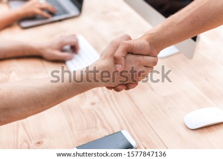 close up. employees shaking hands in the workplace