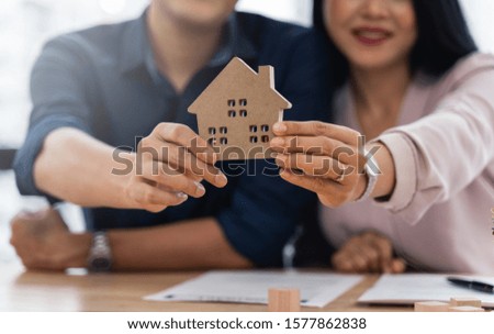 Asian couple showcasing their new home model after they have finished their home contract