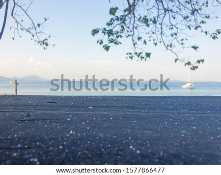 Picture of a wooden table with a blurry background in the sea The atmosphere in the morning and evening is still sunny. Is a natural concept and has space for characters. Copy space. with glasses