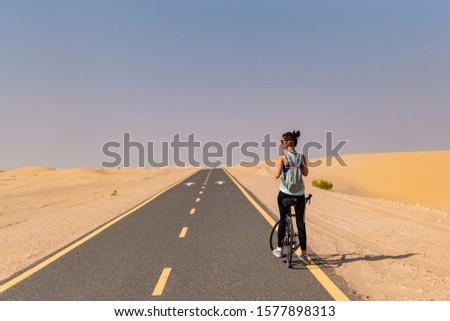 Lady stops cycling to grab a water 