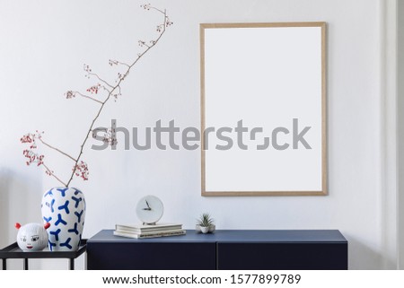 Stylish scandinavian living room with mock up poster frame, navy blue commode, tvase with flowers, clock and elegant accessories. Modern home decor. Interior design. Template Ready to use. 
